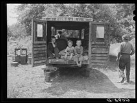 Rear of truck occupied by three children of migrant family from Arkansas. The parents sleep in a small tent. Berrien County, Michigan. Sourced from the Library of Congress.