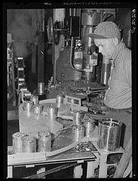 Operating machine which seals cans of cherries. Canning plant, Sturgeon Bay, Wisconsin. Sourced from the Library of Congress.