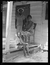 [Untitled photo, possibly related to: Mrs. Calip White and two of her children on front porch of their home near Scotland, Saint Mary's County, Maryland]. Sourced from the Library of Congress.