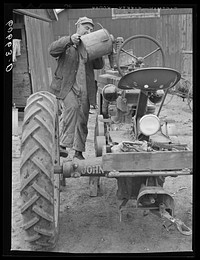 Pouring water in tractor before starting out to plow. Grundy County, Iowa. Sourced from the Library of Congress.