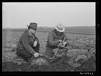 County agent watching farmer adjust plow points. Jasper County, Iowa. Sourced from the Library of Congress.