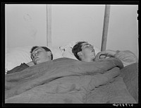 Construction workers sleeping in room in basement of secondhand furniture store. Radford, Virginia. Sourced from the Library of Congress.