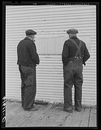 Farmers looking at ballots posted outside of schoolhouse. Election day, McIntosh County, North Dakota. Sourced from the Library of Congress.
