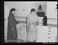 Home supervisor with wife of tenant purchase borrower in new kitchen. Labette County, Kansas. Sourced from the Library of Congress.