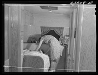 Mrs. Jack Cutter putting children to bed. The dining room of the trailer is converted into a bed. FSA (Farm Security Administration) camp, Erie, Pennsylvania. Sourced from the Library of Congress.
