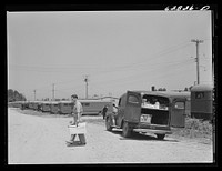 Grocery truck making delivery to trailer. FSA (Farm Security Administration) camp, Erie, Pennsylvania. There are no stores or shops within walking distance of the camp. Sourced from the Library of Congress.