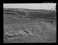 [Untitled photo, possibly related to: World's largest open pit iron mine at Hibbing, Minnesota. The pit is two and a half miles long, three quarters of a mile wide, four hundred feet deep]. Sourced from the Library of Congress.