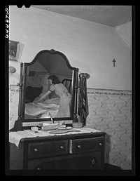 Meeker County, Minnesota. Elaine McCormick, one of the McRaith grandchildren, making the beds in the morning before school bus comes. Sourced from the Library of Congress.