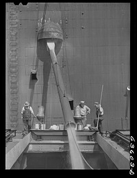 State and federal grain inspectors watching loading operations on grain boat at Occident elevator. Duluth, Minnesota. Sourced from the Library of Congress.