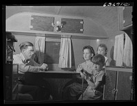 Mr. and Mrs. Birch and family in trailer in Edgewater trailer camp near Ypsilanti, Michigan. Mrs. Birch and the children share the trailer with another family. Mr. Birch lives in a tent nearby with two men. Rent: six dollars a week for trailer space; five dollars a week for tent. Mr. Birch works at the Ford bomber plant. Sourced from the Library of Congress.