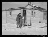 [Untitled photo, possibly related to: Adams County, North Dakota. Mrs. Lee Johnson bringing in a pair of overalls which had been drying on the line and have been frozen stiff]. Sourced from the Library of Congress.