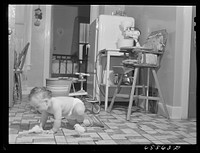 Hamilton, Montana. Son of Ted Barkhoefer, crawling on the kitchen floor. Sourced from the Library of Congress.