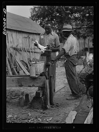 A FSA (Farm Security Administration) supervisor consults a borrower about unsanitary water supply. Safe well demonstration, near La Plata, Maryland. Charles County. Sourced from the Library of Congress.