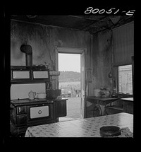 Interior of Biscoe kitchen. A fine stove, but no screens, and the plaster was falling off the walls. John Biscoe farmhouse, Ridge, Maryland. Saint Mary's County. Sourced from the Library of Congress.