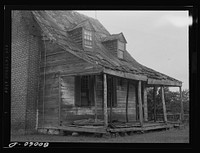 Front porch. No one dares sit out here anymore. John Briscoe farmhouse near Ridge, Maryland. Saint Mary's County. Sourced from the Library of Congress.
