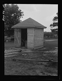 The water from this well is unsafe because surface water washes filth through wooden curbing despite the well house. Safe well demonstration near La Plata, Maryland. Charles County. Sourced from the Library of Congress.