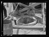 The old wood curbing permitted surface water to wash in between cracks. Safe well demonstration near La Plata, Maryland. Charles County. Sourced from the Library of Congress.