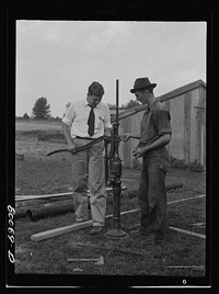 Adjusting the hand pump. Safe well demonstration near La Plata, Maryland. Charles County. Sourced from the Library of Congress.