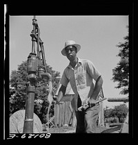 Well worker tries out the pump. John Fredrick well project, Saint Mary's County, Maryland. Sourced from the Library of Congress.