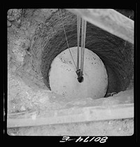 [Untitled photo, possibly related to: Block and tackle hung from windlass serve as a rig to lower cement cap into place. John Hardesty well project, Charles County, Maryland]. Sourced from the Library of Congress.