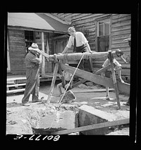 Supervisor stands on windlass to ballast it from toppling into well. John Hardesty well project, Charles County, Maryland. Sourced from the Library of Congress.