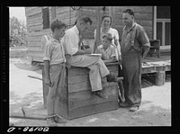 County supervisor talking over home plan with the Hardesty family resting on removed well top. Charles County, Maryland. Sourced from the Library of Congress.