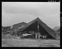 [Untitled photo, possibly related to: Bridgeton, New Jersey. FSA (Farm Security Administration) agricultural workers' camp. Migrants filling ticks with straw to serve as mattresses]. Sourced from the Library of Congress.