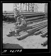 [Untitled photo, possibly related to: Floyd Swick, welder from Newton, Kansas worked in oil fields about ten years; cutting tool joints off a drill pipe in Goodrich field of Continental oil company. Valley Center oil field near Wichita, Kansas]. Sourced from the Library of Congress.