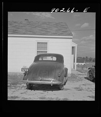 [Untitled photo, possibly related to: "Help Radford Blow The Hell Out Of Hitler" sign on the back of a defense worker's car in front of his home in Sunset Village, FSA (Farm Security Administration) project. Radford, Virginia]. Sourced from the Library of Congress.