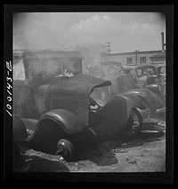 [Untitled photo, possibly related to: Washington, D.C. Scrap salvage campaign, Victory Program. After saleable parts are removed from old cars, the cars are burned in order to strip them of useless materials and to obtain metal skeleton for scrap]. Sourced from the Library of Congress.