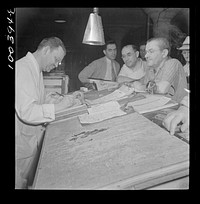 Washington, D.C. District grocery store warehouse on 4th Street S.W. Order clerk settling accounts with merchants who come to make their purchases about 5 a.m.. Sourced from the Library of Congress.