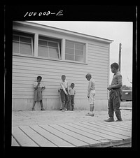 [Untitled photo, possibly related to: Arlington, Virginia. FSA (Farm Security Administration) trailer camp project for es. Children playing marbles outside the community building]. Sourced from the Library of Congress.