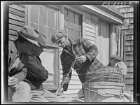 [Untitled photo, possibly related to: Provincetown, Massachusetts. Portuguese dory fisherman coiling down his trawl for the next day's fishing]. Sourced from the Library of Congress.