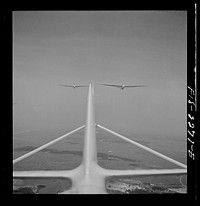 [Untitled photo, possibly related to: Parris Island, South Carolina. U.S. Marine Corps glider detachment training camp. An aerial "tug boat" tows three gliders high above the field]. Sourced from the Library of Congress.