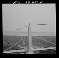 [Untitled photo, possibly related to: Parris Island, South Carolina. U.S. Marine Corps glider detachment training camp. An aerial "tug boat" tows three gliders high above the field]. Sourced from the Library of Congress.