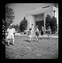 [Untitled photo, possibly related to: Greenbelt, Maryland. Federal housing project. Kindergarten children practice their May Day dances on the grass in front of the school]. Sourced from the Library of Congress.