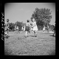 Greenbelt, Maryland. Federal housing project. Kindergarten children practice their May Day dances on the grass in front of the school. Sourced from the Library of Congress.