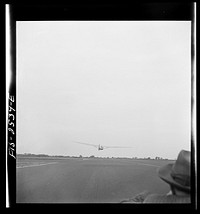 [Untitled photo, possibly related to: Parris Island, South Carolina. U.S. Marine Corps glider detachment training camp. An aerial "tug boat" tows three gliders high above the field]. Sourced from the Library of Congress.