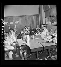 Greenbelt, Maryland. Federal housing project. Third grade children have a discussion about compositions which they have written. Sourced from the Library of Congress.
