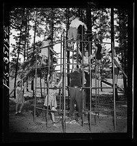 Greenbelt, Maryland. Federal housing project. Children playing on apparatus in one of the numerous playgrounds situated in shady groves. Sourced from the Library of Congress.