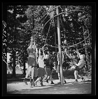 [Untitled photo, possibly related to: Greenbelt, Maryland. Federal housing project. Children playing on apparatus in one of the numerous playgrounds situated in shady groves]. Sourced from the Library of Congress.