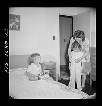 [Untitled photo, possibly related to: Greenbelt, Maryland. Mrs. Atkins putting Ann to bed in her room. Pierce has a room of his own]. Sourced from the Library of Congress.