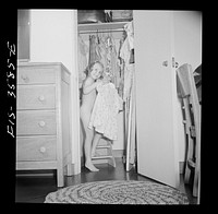 [Untitled photo, possibly related to: Greenbelt, Maryland. Ann Atkins taking a dress out of her closet by climbing on the ladder built especially for her. Ann is six, and moved to Greenbelt when she was a year old]. Sourced from the Library of Congress.