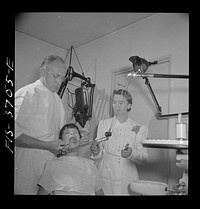 Greenbelt, Maryland. Dr. McCarl, Greenbelt dentist, treating a young patient. Sourced from the Library of Congress.