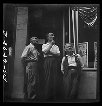 New York, New York. Italian-Americans in the rain watching a flag raising ceremony in honor of the feast of San Rocco at right. Sourced from the Library of Congress.