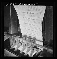 New York, New York. Pressroom of the New York Times department. Finished papers come out of cutting and folding machine on rapidly moving belt. Every fiftieth is automatically slated to facilitate counting. Sourced from the Library of Congress.