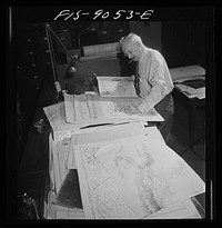 New York, New York. Art department of the New York Times newspaper. Cartographer consults key maps filed for reference in making maps for paper. This man here during last war; claims he can keep at least two countries ahead of the war. Sourced from the Library of Congress.