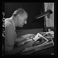 New York, New York. Art department of the New York Times newspaper. Photo retoucher touching up a fashion photograph for Sunday paper. Sourced from the Library of Congress.