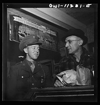 Lititz, Pennsylvania. Private first class Fred D. Long, home on leave from Fort Bliss, Texas, goes shopping with his father, Albert K. Long, who works in the animal trap company's machine shop. Sourced from the Library of Congress.