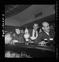 New York, New York. Merchant seamen's Christmas party at the Andrew Feruseth Club on Christmas Day. Drinking beer at the bar. Sourced from the Library of Congress.